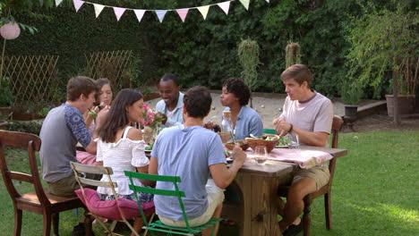 amigos comen y beben en la mesa de la fiesta al aire libre filmado en r3d