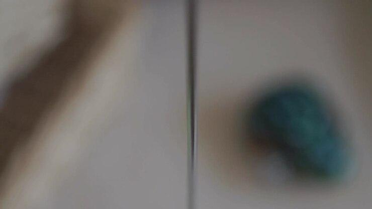 Blurry close-up of a colorful wooden bird toy on a string in motion