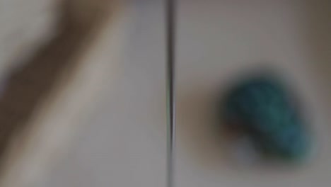 blurry close-up of a colorful wooden bird toy on a string in motion