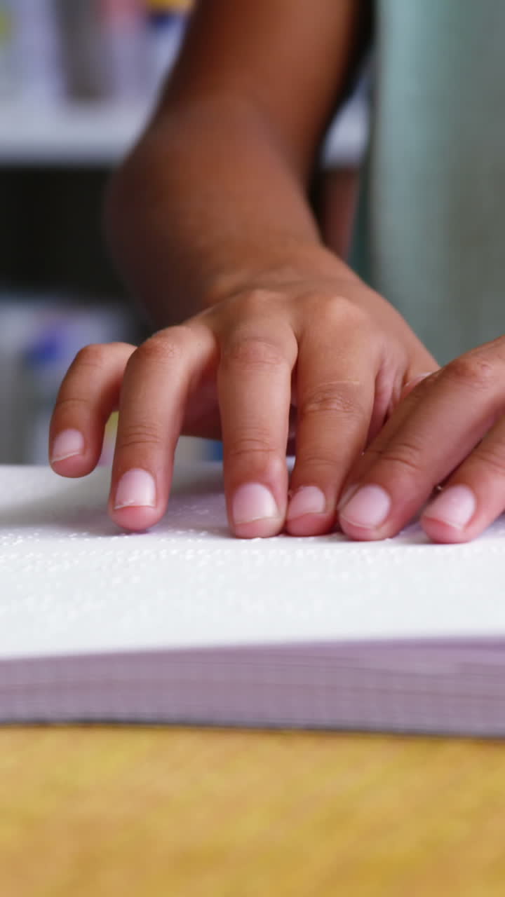 sección media de un niño de escuela leyendo un libro en braille en el aula de la escuela