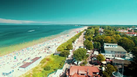 Sonniger-Strand-Voller-Touristen-Beim-Sonnenbaden-Und-Ein-Leuchtturm