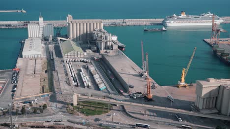 Aerial-View-of-Barcelona-Cargo-Harbour:-Busy-Shipping-Scene-with-Stacked-Containers,-Large-Freighters,-and-Maritime-Activity