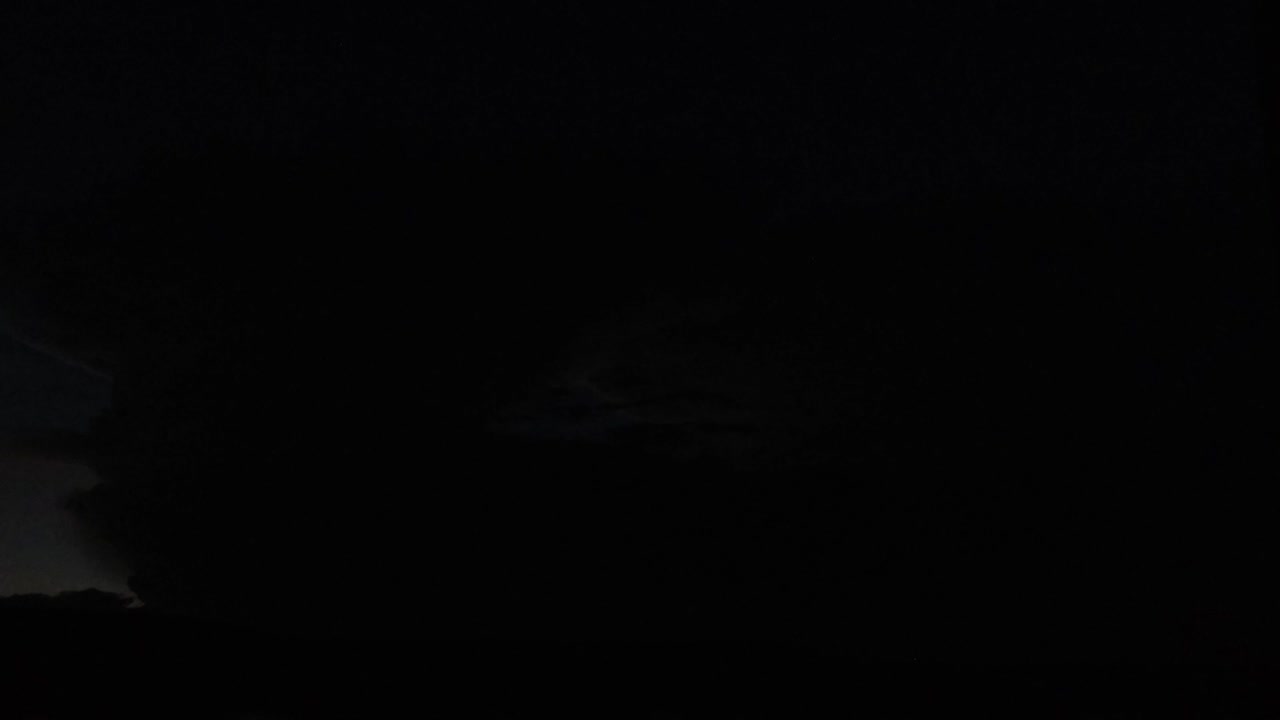 una nube distante por la noche con relámpagos embriagadores sucediendo dentro de ella