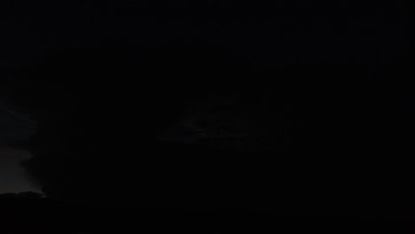 una nube distante por la noche con relámpagos embriagadores sucediendo dentro de ella