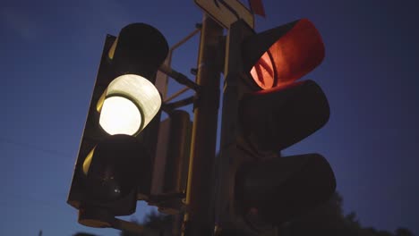 traffic light at dusk with a glowing red signal and a light