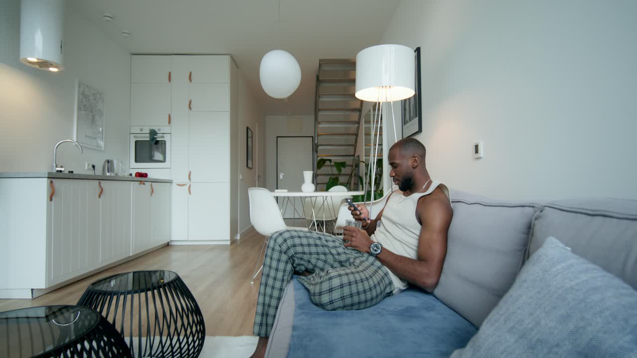 Mand slapper af på sofaen i en moderne lejlighed