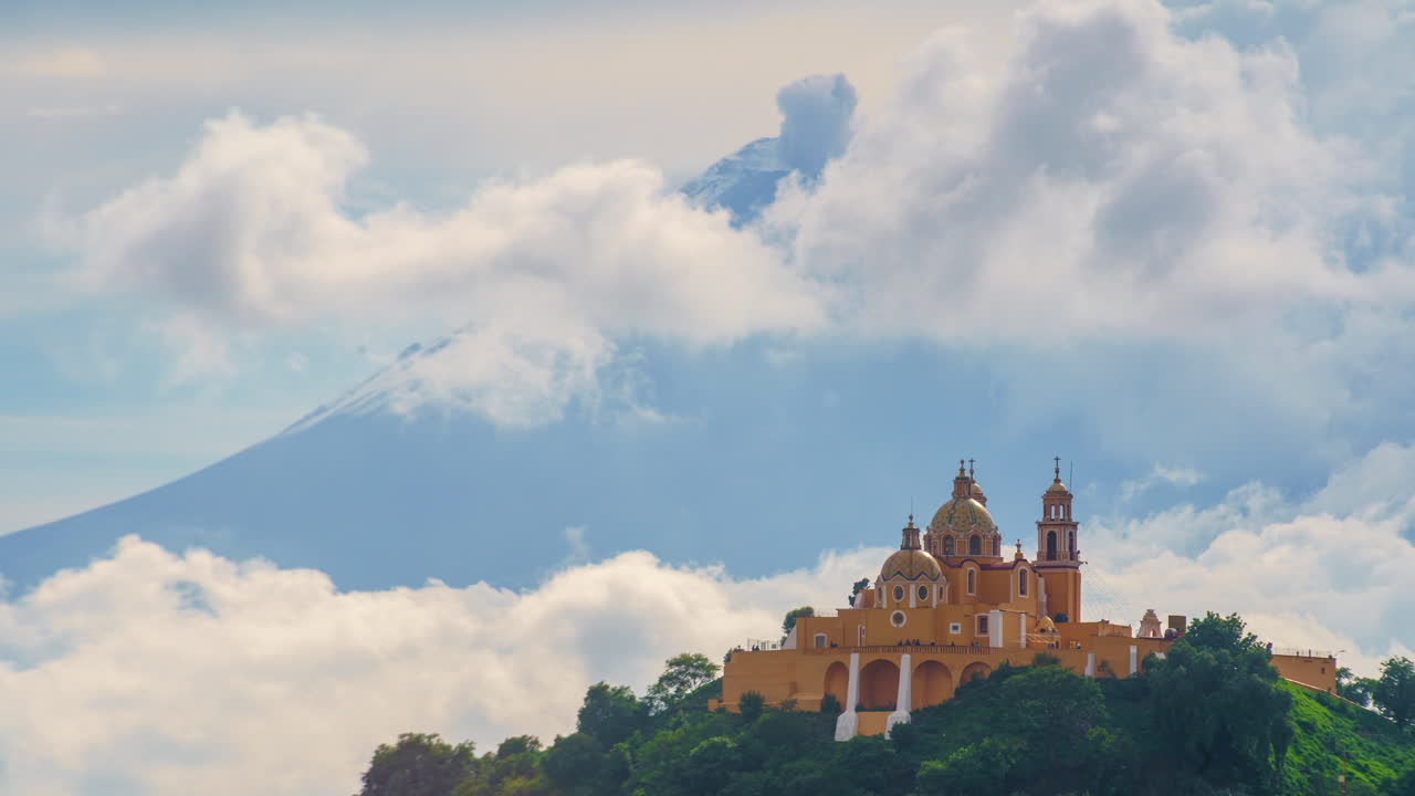 Time-lapse of Our Lady of Remedies Church atop the Great Pyramid in Cholula, Puebla, with the active Popocatépetl volcano erupting and releasing fumaroles in the background