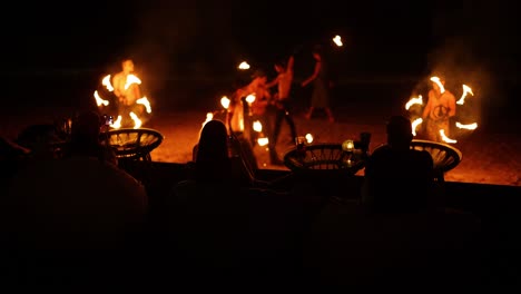 performers juggle fire at a beach event