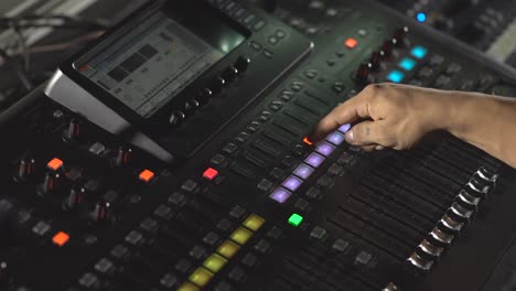 hand pushing butons in mixing console