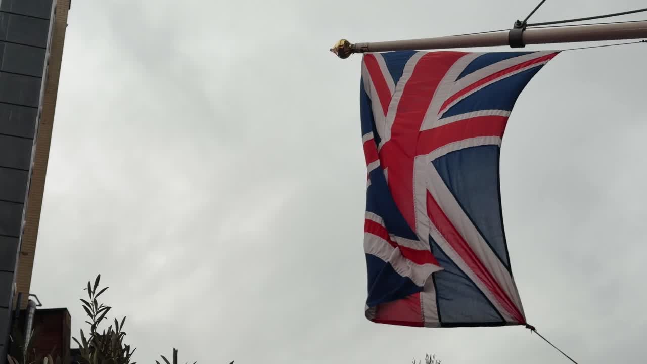 La bandiera britannica con l'Union Jack che sventola al vento su un'asta in Inghilterra, Regno Unito. Primo piano.