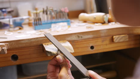 Close-Up-Of-Female-Jeweller-Working-On-Ring-With-File-In-Studio