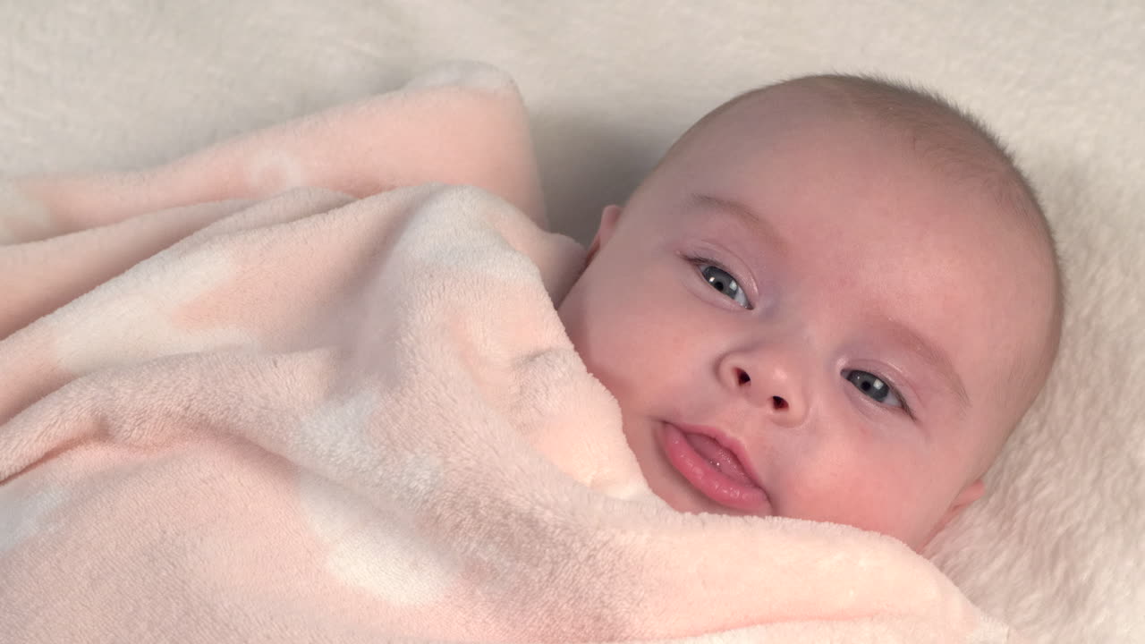 Beautiful Baby newborn is lying in bed and shows hands and feet, mother fandles with baby and covers her up with a cosy coverlet,4k 60p Apple ProRes422, with external Atoms recorder-10