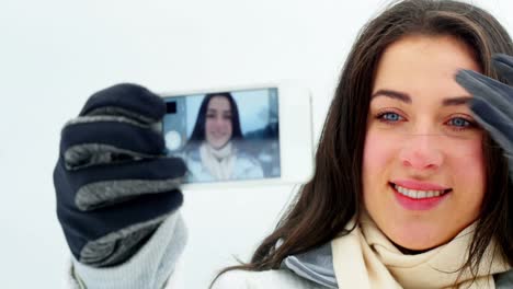 Smiling-woman-taking-selfie-on-mobile-phone