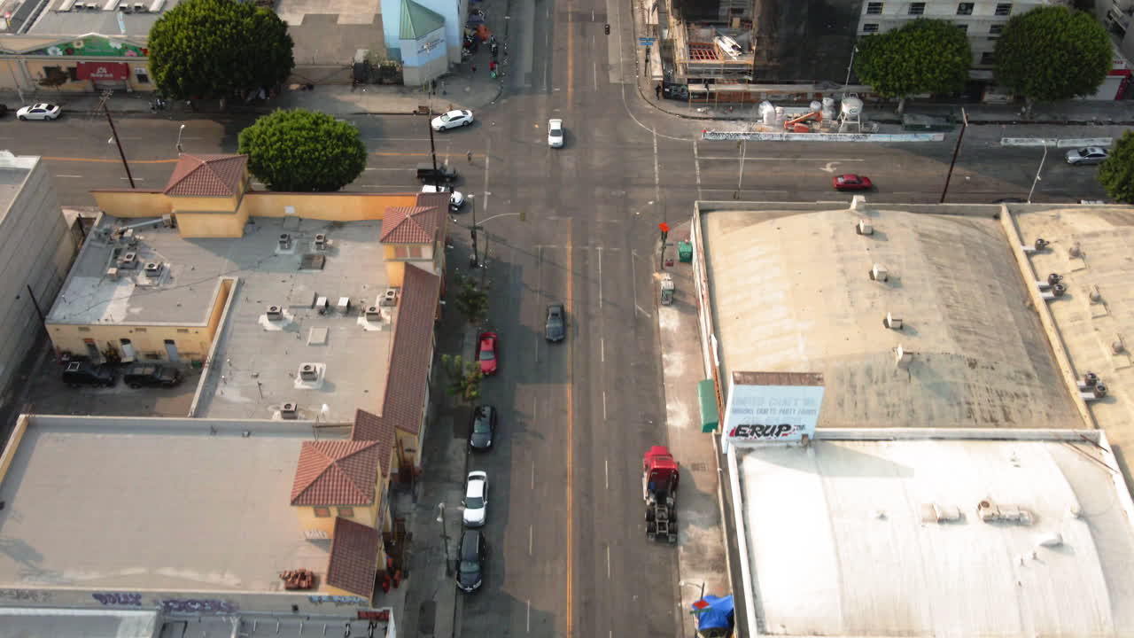 Aerial view of a city street intersection featuring a homeless encampment and urban landscape