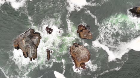 Still-top-down-aerial-view-of-the-waves-swelling-and-crashing-on-the-rocks-on-the-Sonoma-Coast