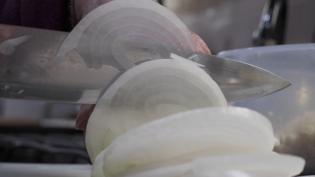 Woman Chopping Onions in Kitchen