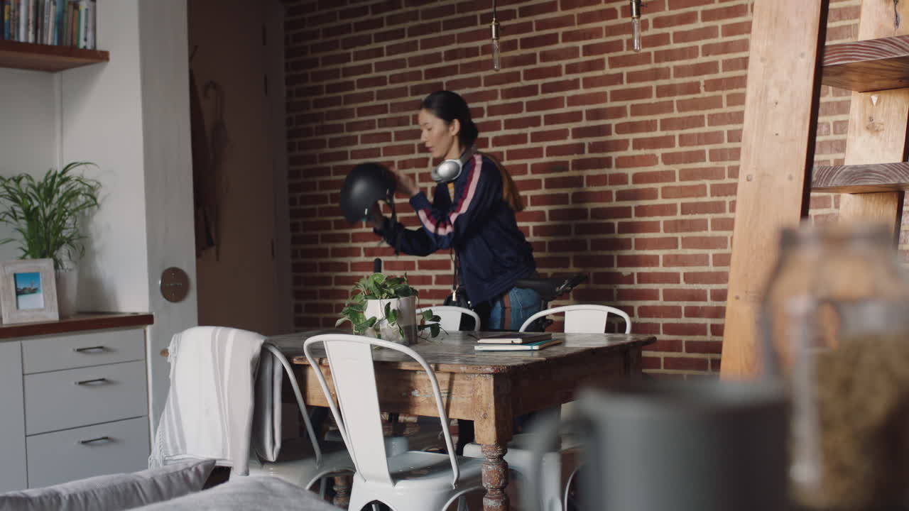 아름다운 아시아 젊은 여성이 자전거를 타고 아파트를 떠날 준비를 하고 있습니다.