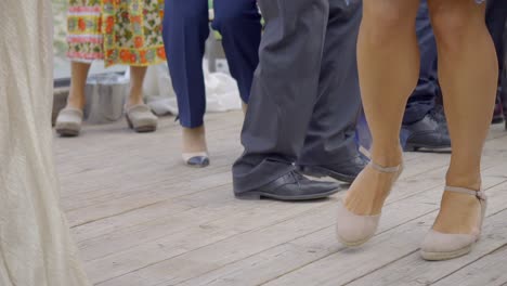 ground shot of people dancing over wooden floor during ceremony