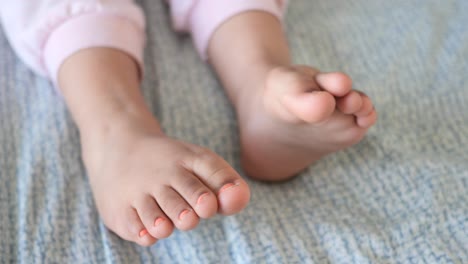 child's feet with painted toenails on a blanket