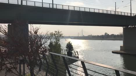 city view of bridge on sava river with sun reflection on water