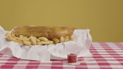 tomada de estudio de una comida tradicional británica de pescado y papas fritas 4