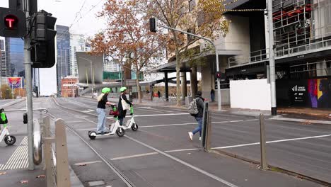 personas montando scooters en una calle de la ciudad