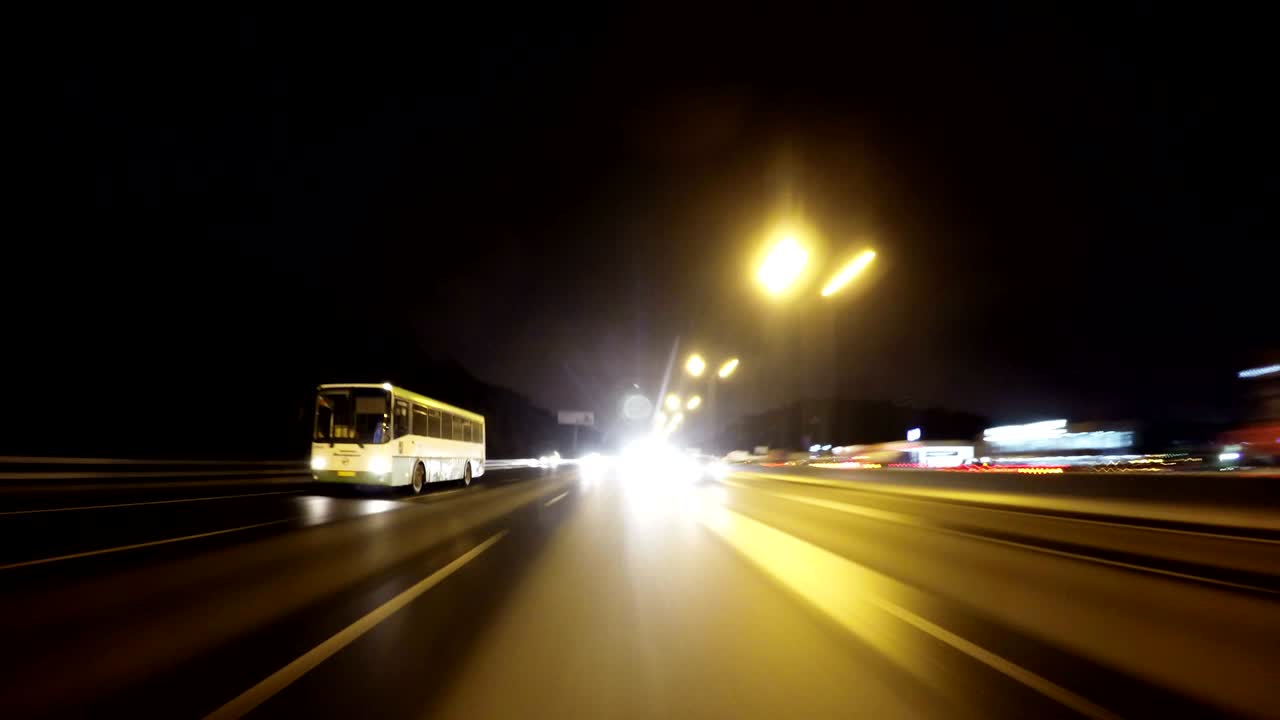 밤에 도시를 가로지르는 도로. 뒤에 있는 자동차의 전망. 루프가 가능합니다.