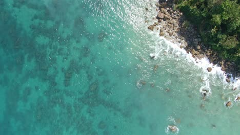 Enjoyable-calming-top-down-shot-of-the-beautiful-nature-view-of-the-turquoise-sea-water-from-shallow-part-of-the-coastline