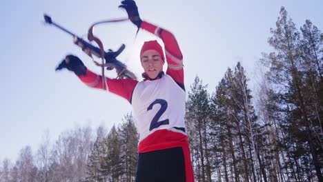 sportsman shooting with rifle during biathlon race