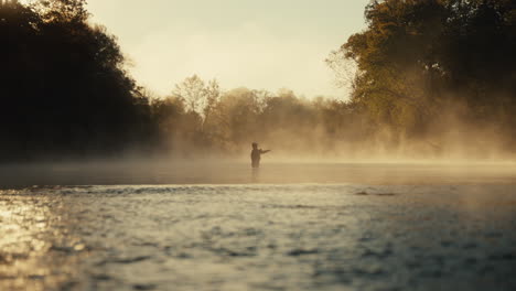 fisherman in misty morning sunrise