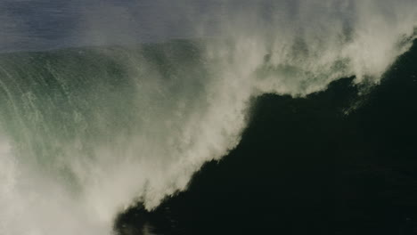 telephoto closeup of powerful ocean wave crashing with mist rising and sparkling in air, slow motion