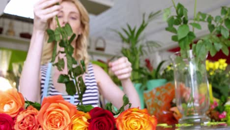 female florist arranging roses in flower shop