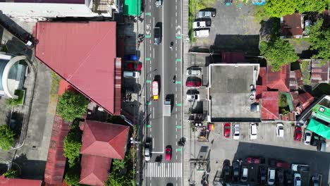 aerial top-down view of busy traffic with trucks and motorcycles driving across town roads in legazpi, albay