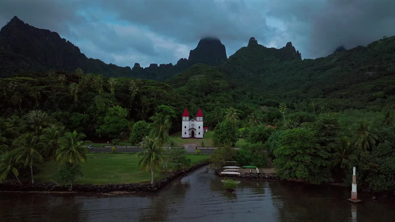 Eglise de la Sainte Famille Church of the Holy Family Moorea Mo'orea French Polynesia drone aerial Tahiti Pacific Island Catholic historic building Temple of Papetoa dark cloudy moody forward motion