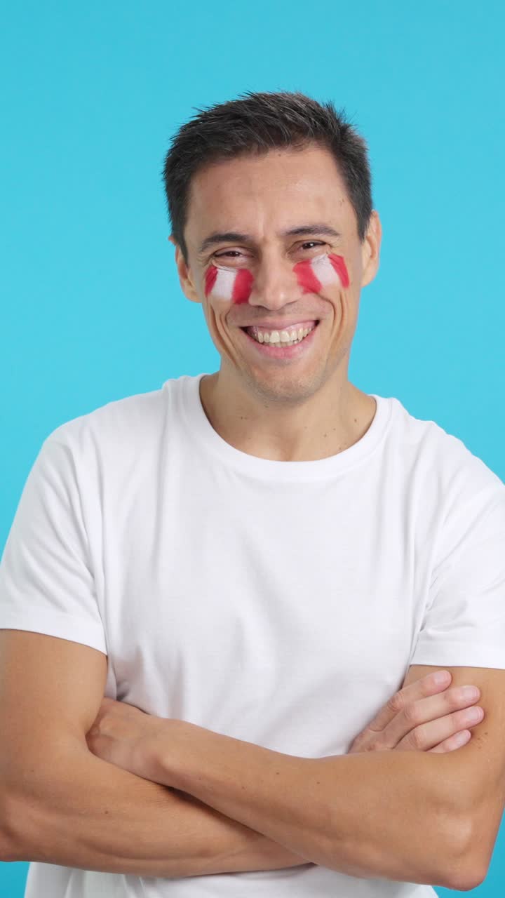 Man standing with peruvian flag painted on face smiling