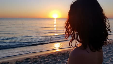 as the sun begins to set over the tranquil waters, a person stands on the sandy beach, facing the horizon. the soft waves gently lap against the shore, creating a soothing ambiance. the sky is filled with a beautiful array of colors, from deep oranges to soft pinks, reflecting on the water's surface