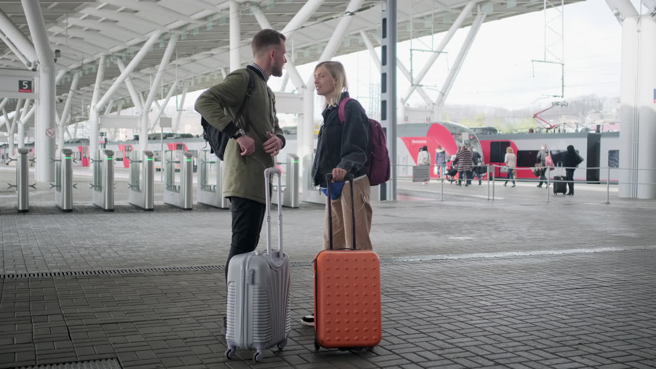 pareja esperando el tren en la estación con equipaje