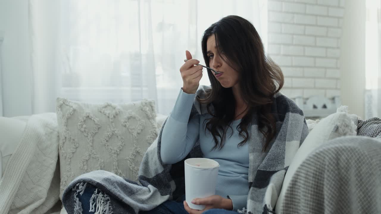 소파에서 아이스크림을 먹는 여자