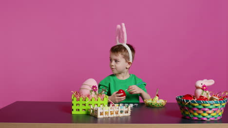 Smiling-jolly-preschooler-painting-eggs-and-ornaments-for-easter-festivity