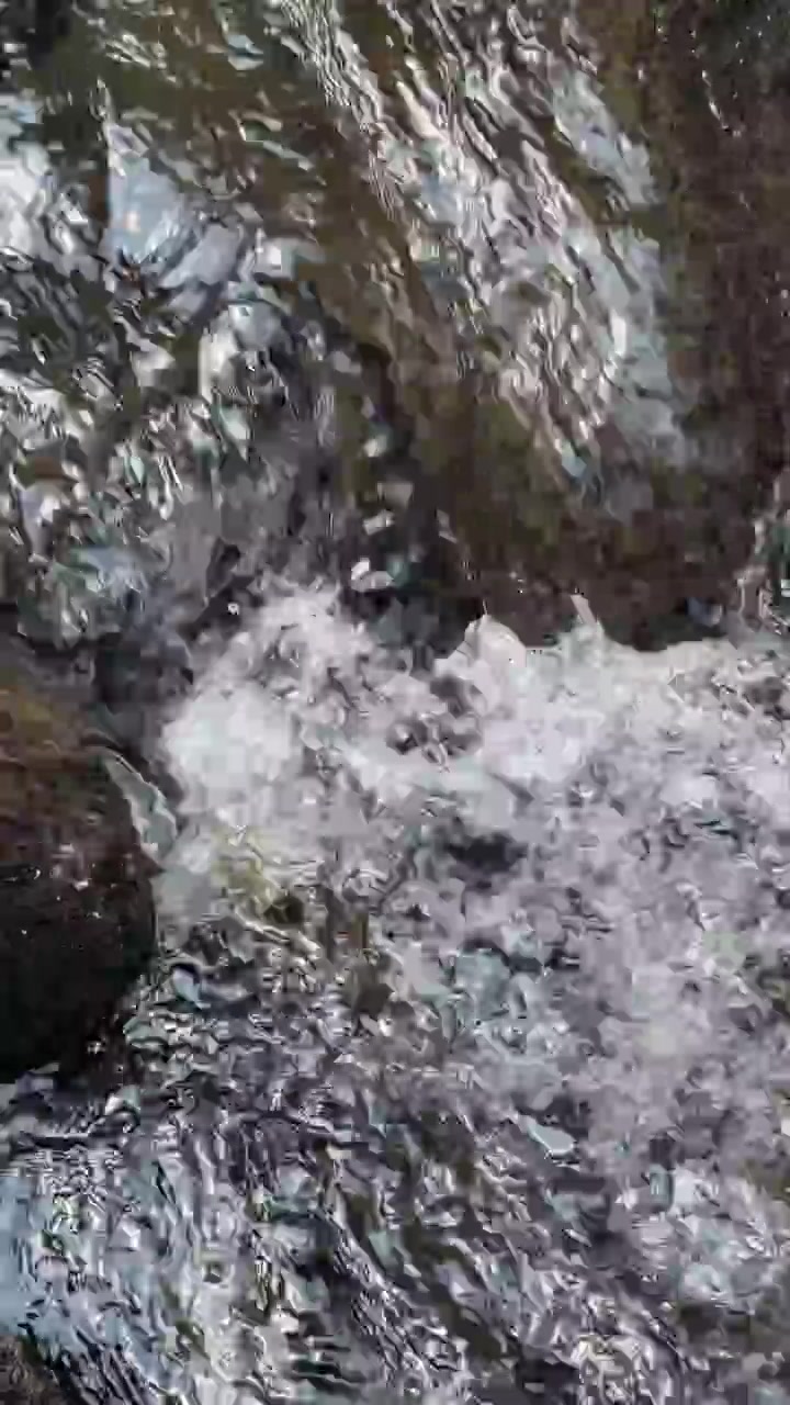 Acqua limpida che scorre sopra rocce scure del fiume