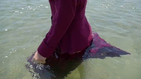 Close-up-of-a-woman-wearing-a-dress-walking-out-to-sea