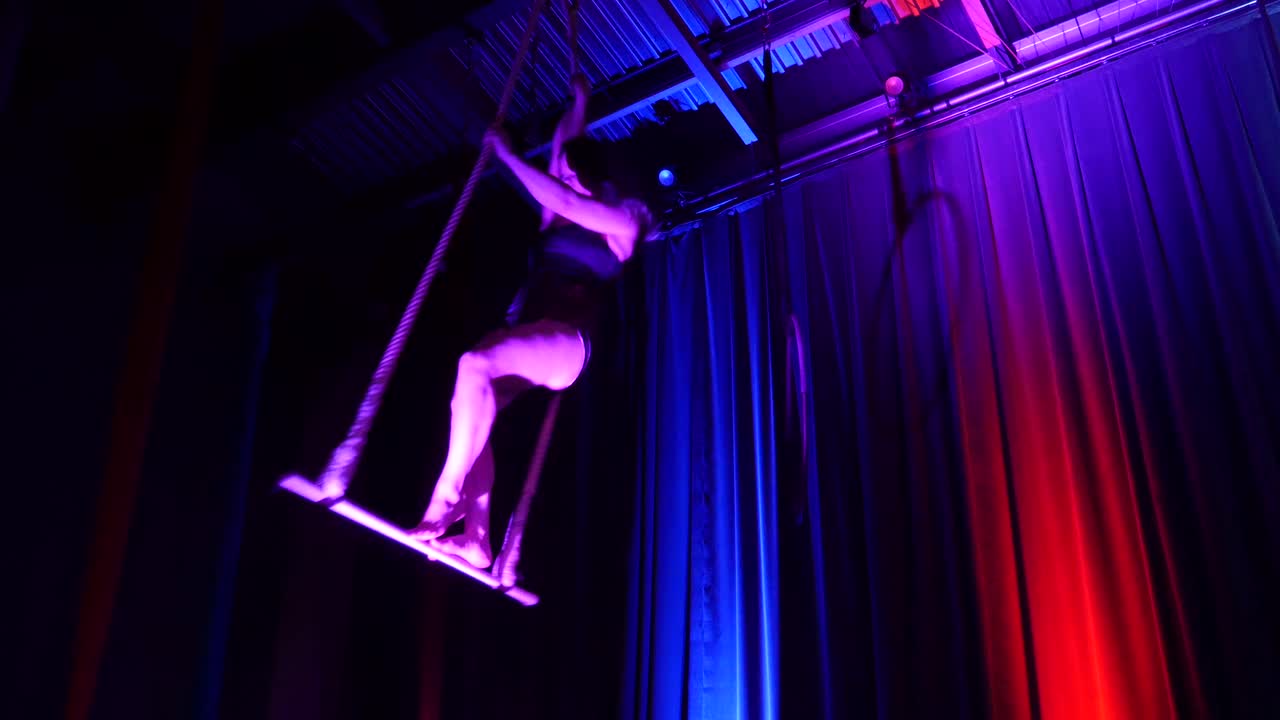 Ragazza acrobata aerea che balla sul trapezio.