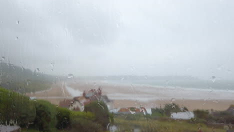 Gotas-De-Lluvia-Cayendo-Contra-Una-Ventana-Con-Vista-Al-Mar-En-Tiempo-Real