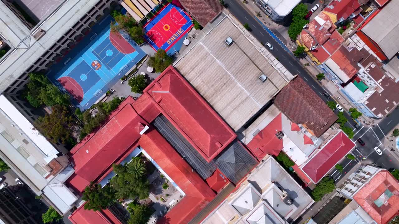 Top-Down Drone Shot of Historic Church in Downtown Santiago Surrounded by Colorful Rooftops and City Streets