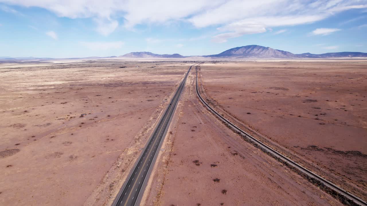 몇 대의 자동차가 운전하는 고속도로와 철도의 패닝 드론 샷