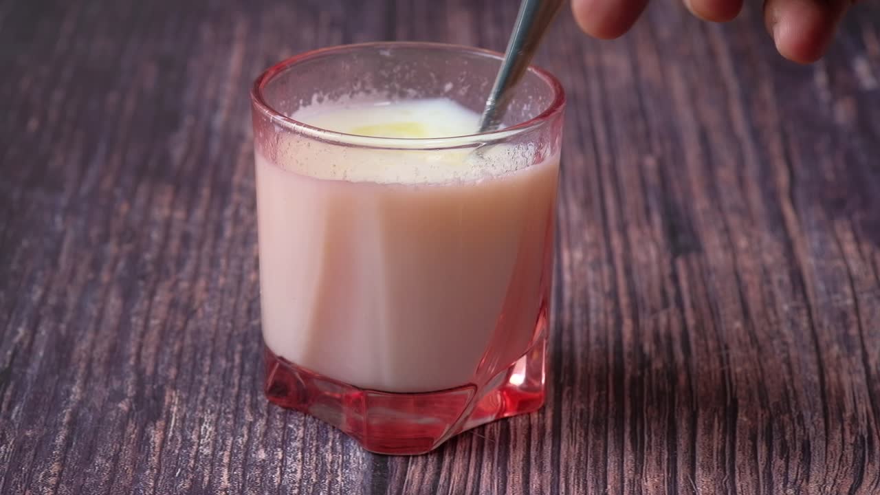 Latte in un bicchiere con un cucchiaio