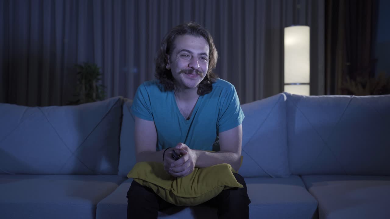 Glad mand ser sine yndlings-tv-serier derhjemme om natten