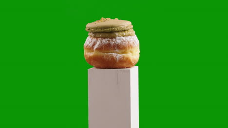 pistachio macaron jelly doughnut, sufganiyah accent and crushed nuts make this doughnut a gourmet centerpiece on chroma key or green screen