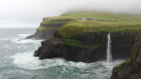 picturesque múlafossur waterfall and wild atlantic ocean faroe islands