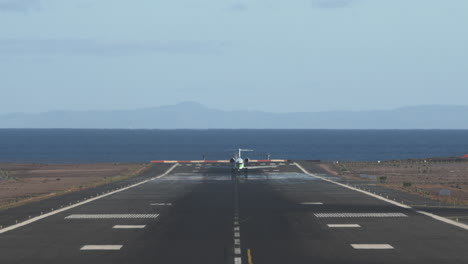 airliner taking off scenic runway overlooking sea and mountains